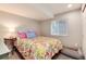 Bedroom features a colorful bed, natural light and space for a dog bed at 11181 W Crestline Dr, Littleton, CO 80127