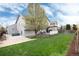 Back exterior showing the backyard with deck and patio, and a large tree at 11181 W Crestline Dr, Littleton, CO 80127
