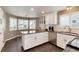 Spacious kitchen featuring stainless steel appliances, white cabinets, and a cozy breakfast nook at 11181 W Crestline Dr, Littleton, CO 80127