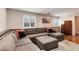 Living room with hardwood floors, large sectional, modern décor, and natural light at 11181 W Crestline Dr, Littleton, CO 80127