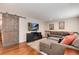 Living room boasts hardwood floors, large gray sectional, and stylish barn door at 11181 W Crestline Dr, Littleton, CO 80127