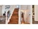 Elegant wood staircase with white railings leading to the upper level with a bathroom at 11181 W Crestline Dr, Littleton, CO 80127