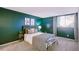 Stylish bedroom featuring green accent wall, wood headboard, and cool-toned decor at 12470 E Cornell Ave # 104, Aurora, CO 80014