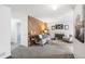 Bright living room features a fireplace, wood accent wall, comfortable seating, and neutral carpet at 12470 E Cornell Ave # 104, Aurora, CO 80014