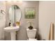 A well decorated bathroom with a pedestal sink, oval mirror, and modern commode at 2616 Loon Cir, Castle Rock, CO 80104
