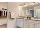 Bathroom with double vanity, granite countertop, white cabinets, and closet area at 2616 Loon Cir, Castle Rock, CO 80104