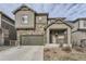 Charming two-story home featuring stone accents, a front porch, a two-car garage, and a well-maintained lawn at 2616 Loon Cir, Castle Rock, CO 80104