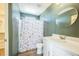 Well-maintained bathroom with a modern vanity and stylish floral shower curtain at 18211 E 51St Ave, Denver, CO 80249