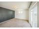 Spacious bonus room with gray accent wall, large windows, and sliding door to outdoor balcony at 18211 E 51St Ave, Denver, CO 80249