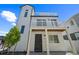 Stunning three-story home featuring a white exterior, balconies, and modern architectural details at 18211 E 51St Ave, Denver, CO 80249