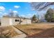 A charming backyard with a grassy area, surrounded by mature trees, a small patio and a path at 3299 S Forest St, Denver, CO 80222