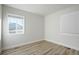 Bright bedroom featuring wood-look flooring and a large window allowing natural light to fill the space at 3299 S Forest St, Denver, CO 80222