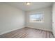 Bright bedroom featuring wood-look flooring, neutral paint and a large window allowing natural light to fill the space at 3299 S Forest St, Denver, CO 80222