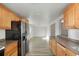 Open kitchen with stainless steel fridge, wood cabinets, and views into the living area at 3299 S Forest St, Denver, CO 80222
