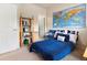 Cozy bedroom with blue accents, a world map, and a bookcase for extra storage at 1801 S Dunkirk St # 205, Aurora, CO 80017
