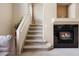 Living room showcases a cozy fireplace with black tile and a carpeted staircase at 1801 S Dunkirk St # 205, Aurora, CO 80017