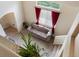 An overhead shot of the living room featuring red curtains and a beige couch at 1801 S Dunkirk St # 205, Aurora, CO 80017