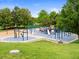Community playground featuring swings, slides, and climbing structures surrounded by lush greenery at 1801 S Dunkirk St # 205, Aurora, CO 80017