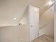 Carpeted staircase leading to a room with a closed, white door at 1801 S Dunkirk St # 205, Aurora, CO 80017