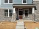 Close up front door and covered porch with a combination of stone and siding exterior and new landscaping at 791 N Tempe St, Aurora, CO 80018