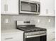 Close up of a kitchen with stainless steel appliances and grey backsplash at 791 N Tempe St, Aurora, CO 80018