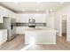 A modern kitchen featuring stainless steel appliances, white cabinetry, center island and light wood floors at 791 N Tempe St, Aurora, CO 80018