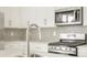 Kitchen with stainless steel appliances, grey backsplash, and white cabinets at 791 N Tempe St, Aurora, CO 80018