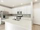 A modern kitchen featuring stainless steel appliances, white cabinetry, gray backsplash and light wood floors at 791 N Tempe St, Aurora, CO 80018