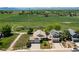 Aerial view of a house with a two-car garage, lush green fields, and mountains in the distance at 1264 Banner Cir, Erie, CO 80516