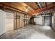 Unfinished basement featuring concrete floors, exposed beams, ductwork, and access to a finished area at 1264 Banner Cir, Erie, CO 80516