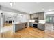 Modern kitchen with sleek gray cabinetry, stainless steel appliances, and an open view to the living room at 17058 Hastings Ct, Parker, CO 80134