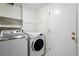 Functional laundry room with modern washer and dryer, and convenient shelving at 17058 Hastings Ct, Parker, CO 80134