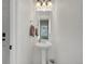 Clean powder room with a pedestal sink and decorative mirror at 19155 Robins Dr, Denver, CO 80249