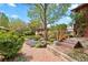 Lush backyard featuring a brick pathway, mature trees, and colorful flowers at 1439 S Emerson St, Denver, CO 80210