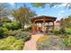 Serene backyard featuring a charming wooden gazebo with seating, surrounded by lush greenery and flowers at 1439 S Emerson St, Denver, CO 80210