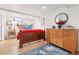 Well-lit bedroom with hardwood floors, a decorative rug, and a dresser, creating a warm atmosphere at 1439 S Emerson St, Denver, CO 80210
