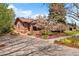 Charming brick home with a well-maintained front yard, colorful flowers, and mature trees at 1439 S Emerson St, Denver, CO 80210