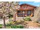 Quaint brick home with blooming tree, mature landscaping, and inviting porch at 1439 S Emerson St, Denver, CO 80210