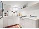 A bright white kitchen with a compact design, featuring essential appliances and plenty of storage at 1439 S Emerson St, Denver, CO 80210