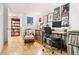 Bright home office featuring a wall of records, hardwood floors, a computer desk, and a view into a library at 1439 S Emerson St, Denver, CO 80210