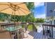 Backyard deck with outdoor dining under a large umbrella, leading to a patio at 9890 Gaylord St, Thornton, CO 80229
