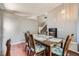Dining room with wood table and stairs visible, light neutral wall color and flooring transition at 9890 Gaylord St, Thornton, CO 80229