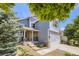 Two-story home with well-kept lawn, two-car garage, and stone facade details on the front porch at 9890 Gaylord St, Thornton, CO 80229