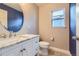 Charming half-bath features a marble vanity and round mirror at 4774 Waldenwood Dr, Highlands Ranch, CO 80130