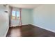 Cozy bedroom featuring hardwood floors, light blue walls, and a curtained window at 4774 Waldenwood Dr, Highlands Ranch, CO 80130