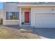 Charming home with a red front door, large window, and well-maintained lawn. Shows detail of the entryway at 4774 Waldenwood Dr, Highlands Ranch, CO 80130