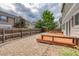 Backyard featuring a wood deck, stone patio, gravel, mature trees, and a privacy fence at 7345 S Nucla St, Aurora, CO 80016