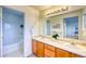 Well-lit bathroom with double sinks, vanity, large mirror, and a shower-tub combination at 7345 S Nucla St, Aurora, CO 80016
