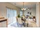 Sunlit dining area with modern chandelier, seating for four, and sliding glass doors to outdoor space at 7345 S Nucla St, Aurora, CO 80016