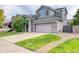 Charming two-story home with a well-manicured lawn, stone accents, and an attached two-car garage at 7345 S Nucla St, Aurora, CO 80016